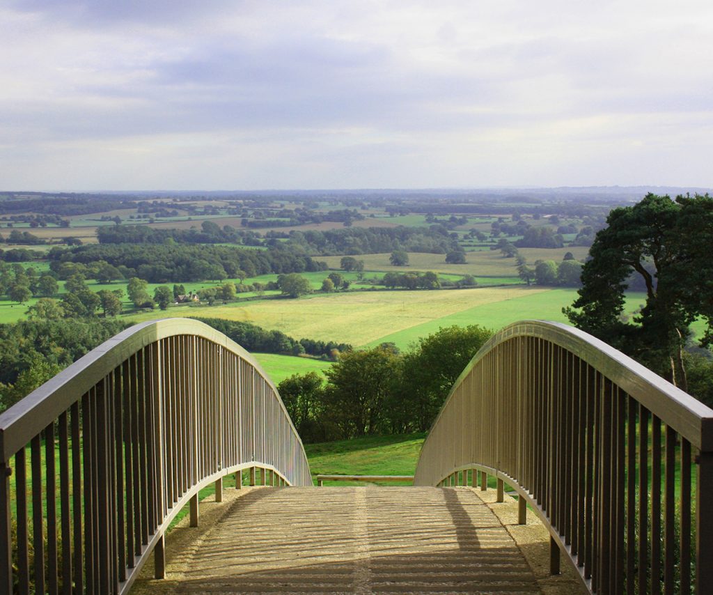 View over a pedestrian bridge at Beeston Castle of farmland
